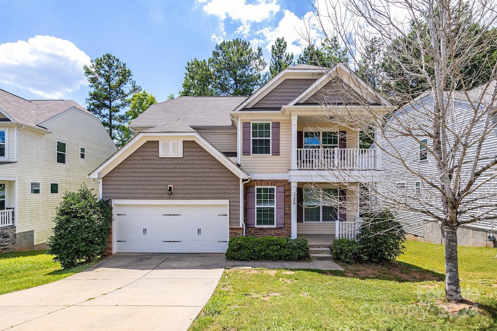 craftsman-style house with a balcony, a front lawn, and a garage