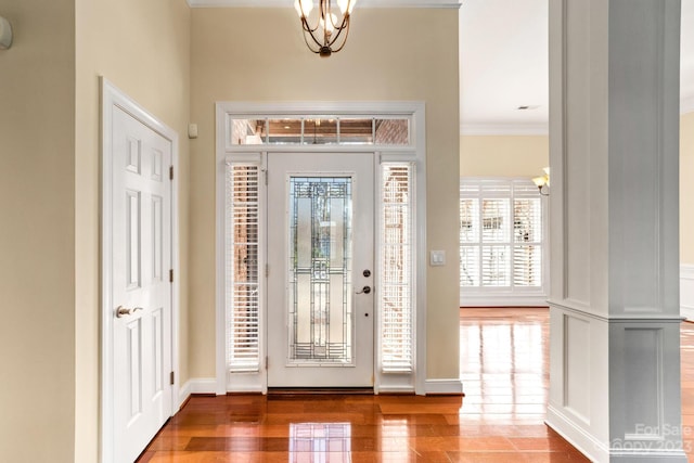 foyer entrance with hardwood / wood-style floors, a chandelier, and ornamental molding