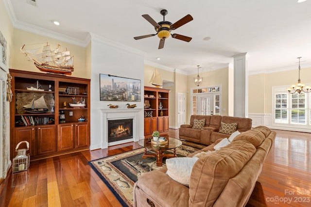 living room featuring french doors, crown molding, dark wood-type flooring, and ceiling fan with notable chandelier