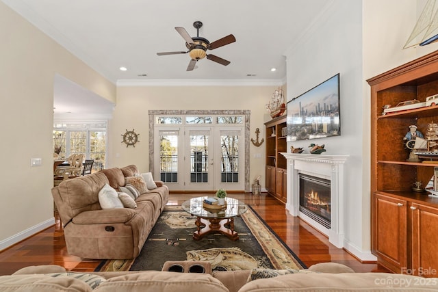 living room with dark hardwood / wood-style flooring, crown molding, and ceiling fan with notable chandelier