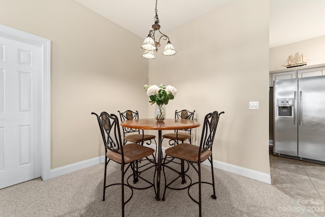 carpeted dining room with a notable chandelier and lofted ceiling