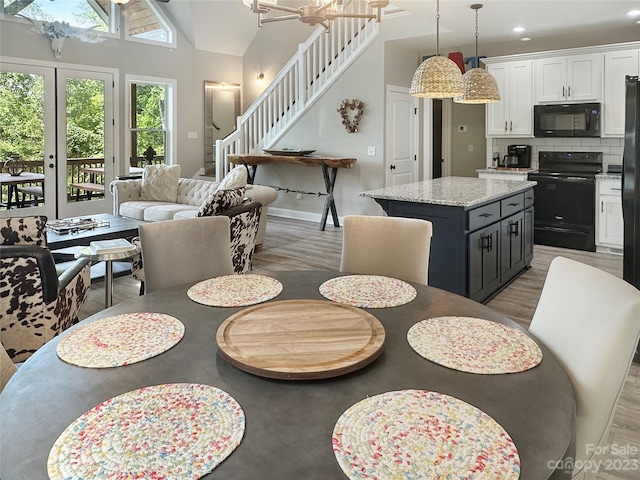 dining area with a high ceiling and light hardwood / wood-style flooring