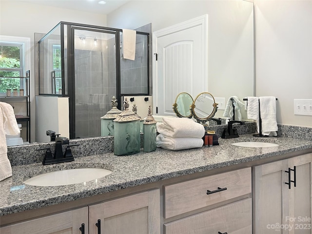 bathroom with double sink vanity and walk in shower