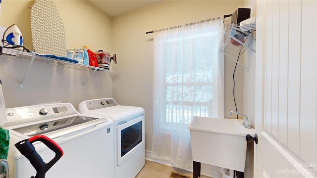 laundry area featuring light tile floors, sink, and washing machine and clothes dryer