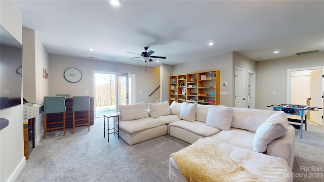 carpeted living room featuring ceiling fan