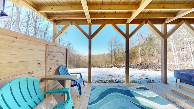 snow covered patio featuring a wooden deck