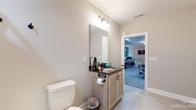 bathroom with tile flooring, toilet, and vanity