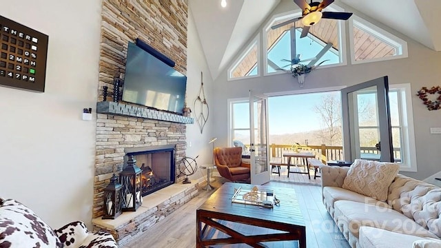 living room with high vaulted ceiling, ceiling fan, a wealth of natural light, and a fireplace