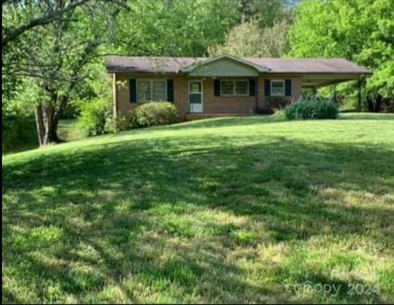 single story home featuring a front lawn