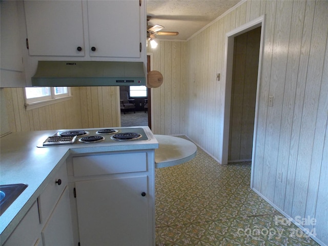 kitchen with custom exhaust hood, crown molding, white cabinetry, light tile floors, and ceiling fan