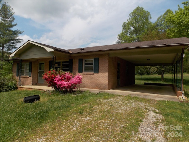 view of front of property with a carport and a front lawn