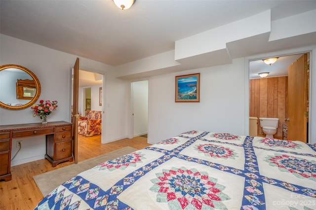 bedroom featuring ensuite bathroom and light hardwood / wood-style flooring