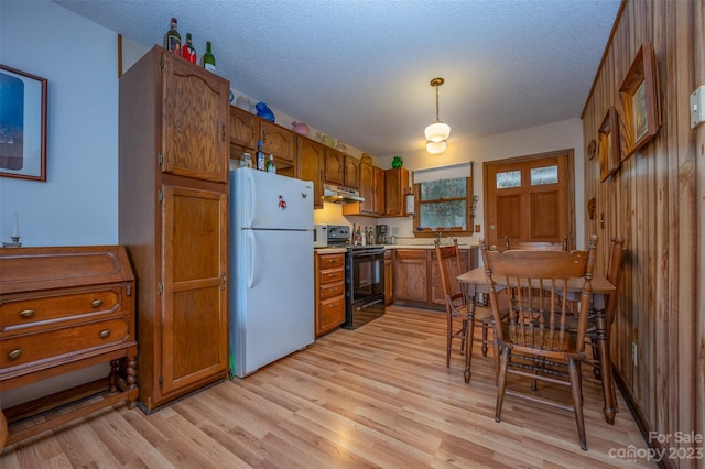 kitchen featuring decorative light fixtures, light hardwood / wood-style flooring, white fridge, and electric range