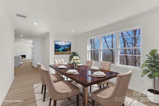 dining room featuring ornamental molding and light wood-type flooring