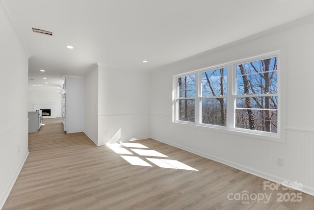 empty room featuring ornamental molding and light hardwood / wood-style floors