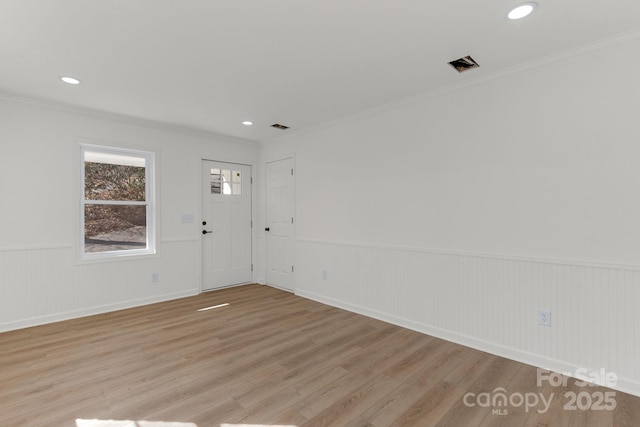 spare room with crown molding and light hardwood / wood-style floors