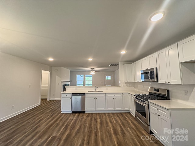 kitchen featuring kitchen peninsula, appliances with stainless steel finishes, ceiling fan, dark wood-type flooring, and white cabinets