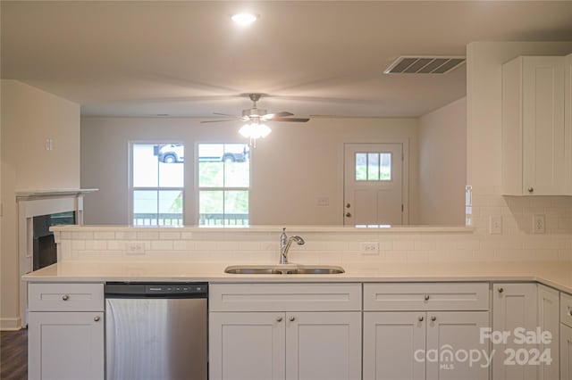 kitchen featuring backsplash, ceiling fan, dishwasher, white cabinets, and sink