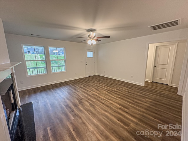 unfurnished living room featuring ceiling fan and dark hardwood / wood-style flooring