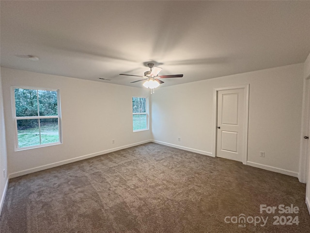 carpeted spare room featuring ceiling fan and a wealth of natural light