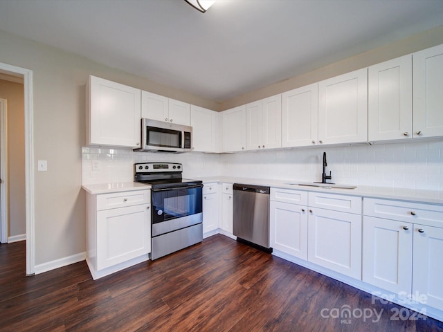 kitchen featuring dark hardwood / wood-style flooring, tasteful backsplash, white cabinets, stainless steel appliances, and sink