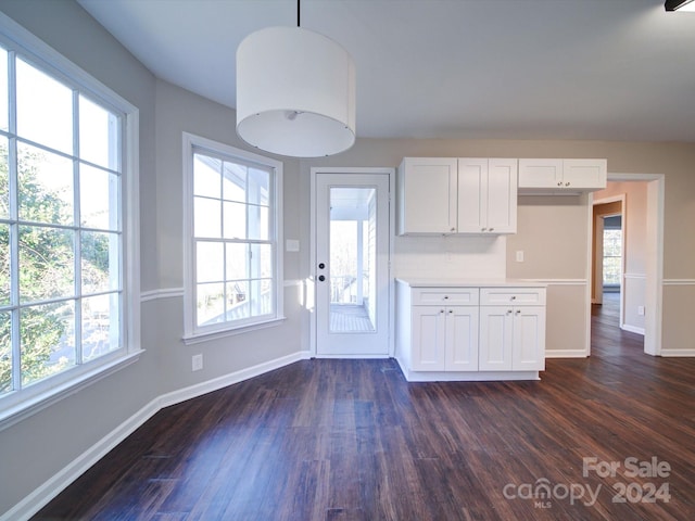 kitchen with white cabinets, hanging light fixtures, backsplash, and dark hardwood / wood-style flooring