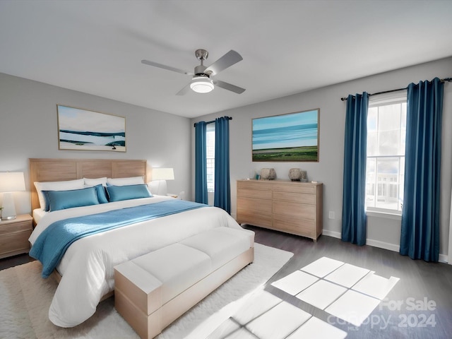 bedroom featuring multiple windows, hardwood / wood-style flooring, and ceiling fan