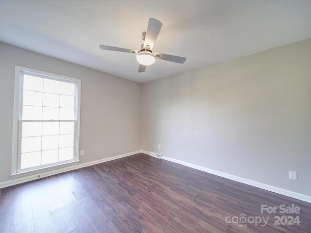 spare room with dark hardwood / wood-style floors, ceiling fan, and a wealth of natural light