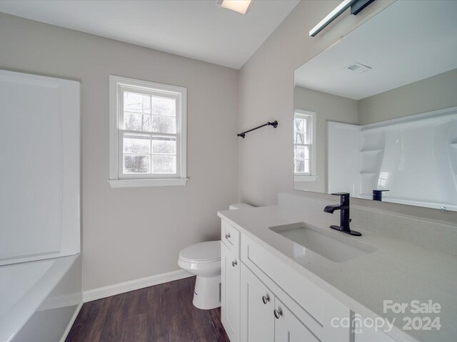 full bathroom with hardwood / wood-style flooring, toilet, bathtub / shower combination, and vanity