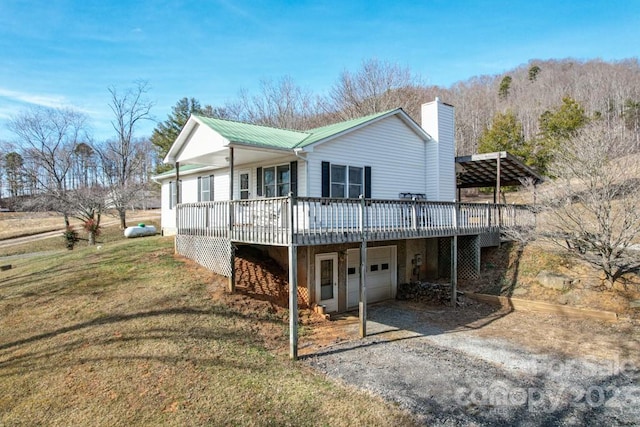 back of house featuring a lawn and a wooden deck