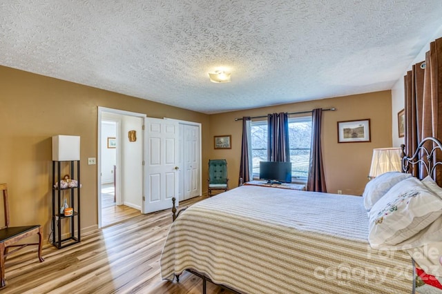 bedroom featuring a textured ceiling and light hardwood / wood-style floors