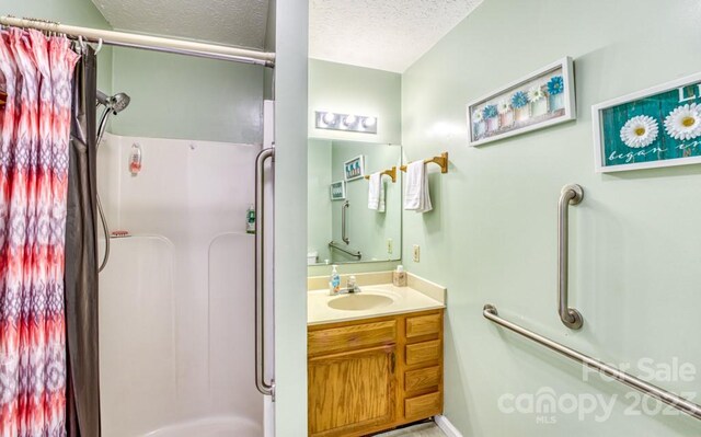 bathroom with a textured ceiling, vanity with extensive cabinet space, and bathing tub / shower combination