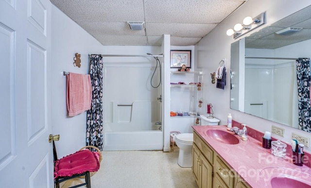 full bathroom with a drop ceiling, dual bowl vanity, toilet, and shower / bathtub combination with curtain