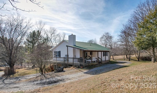 rear view of house with a porch and a lawn