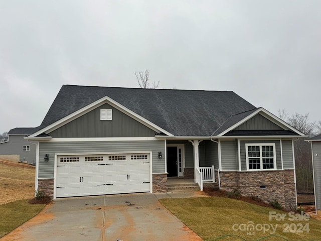 craftsman inspired home featuring a garage and a front yard