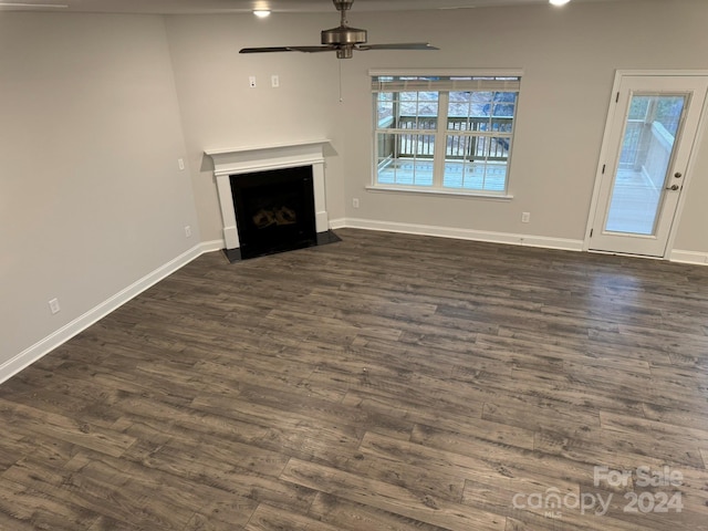 unfurnished living room with dark hardwood / wood-style floors and ceiling fan