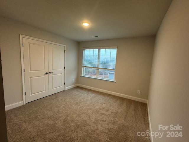 unfurnished bedroom featuring carpet floors and a closet