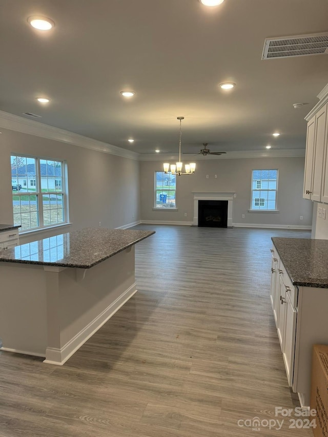 kitchen with plenty of natural light, white cabinetry, and dark stone counters