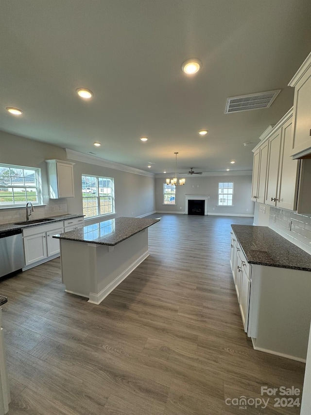 kitchen with dishwasher, white cabinetry, dark stone countertops, and sink