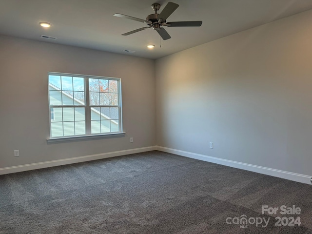 carpeted spare room featuring ceiling fan