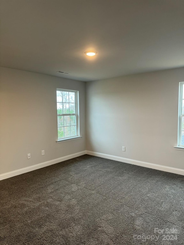 empty room featuring dark colored carpet