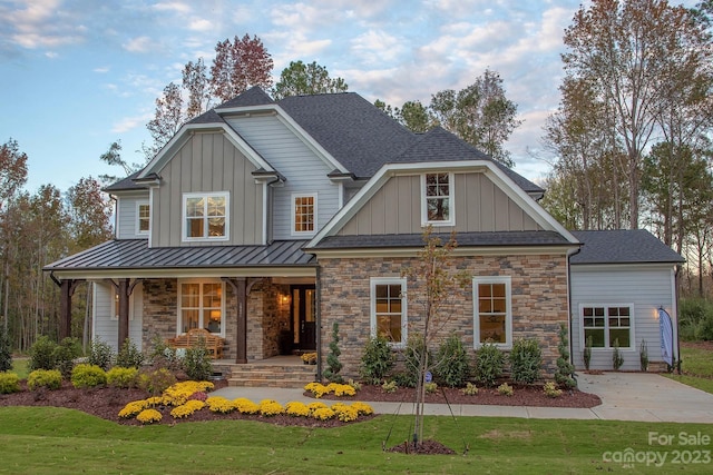 craftsman house featuring covered porch and a front lawn