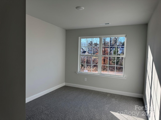 spare room with dark colored carpet