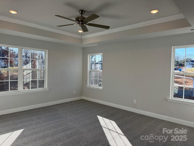 unfurnished room featuring dark colored carpet, a tray ceiling, ceiling fan, and crown molding