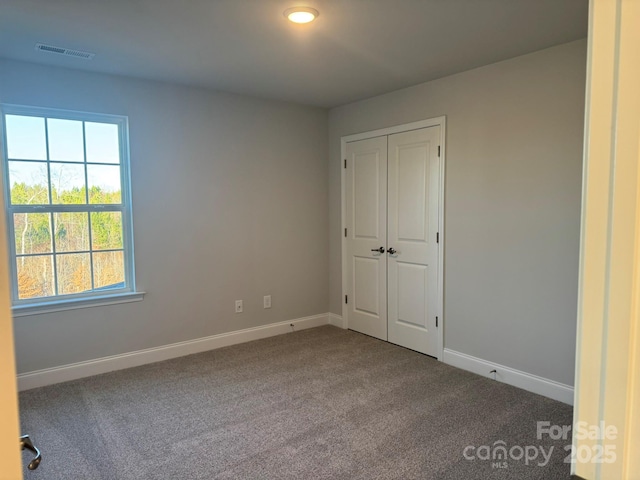 unfurnished bedroom with carpet flooring and a closet