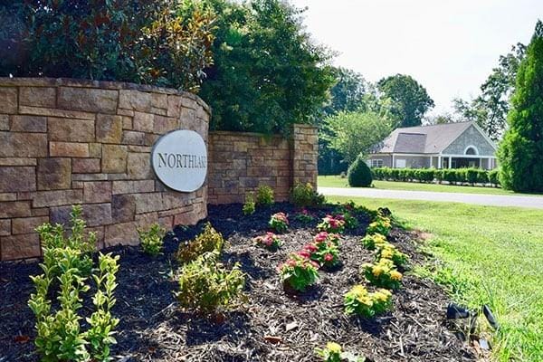 community / neighborhood sign with a yard