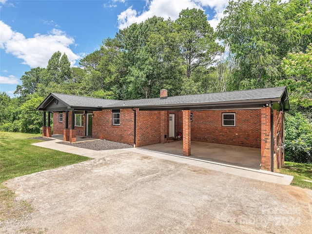 ranch-style house with a front yard and a carport