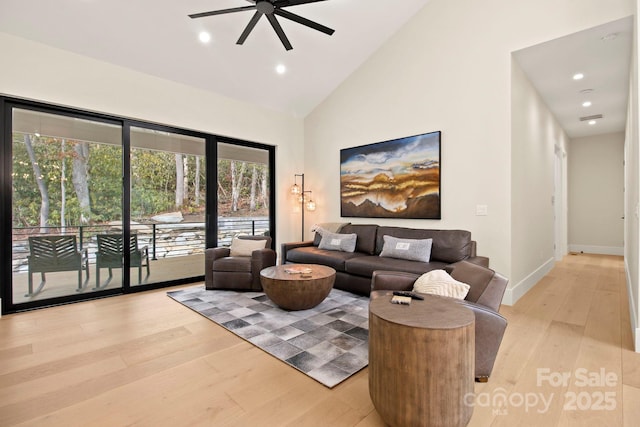 living room with high vaulted ceiling, ceiling fan, and light wood-type flooring