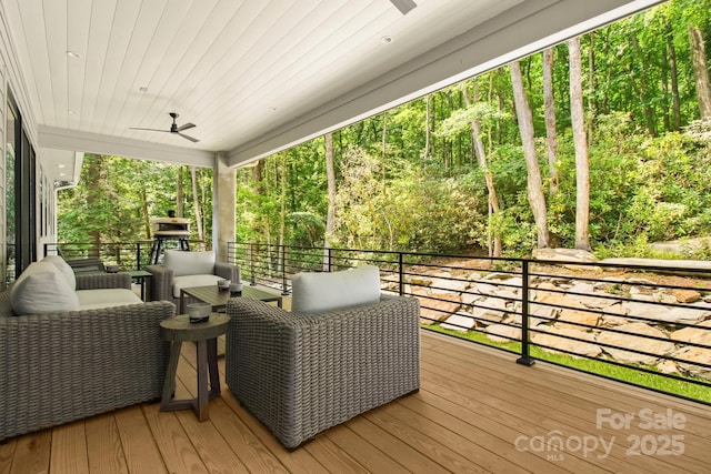 wooden terrace with ceiling fan and an outdoor hangout area