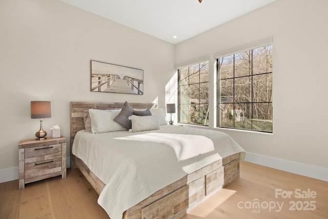 bedroom featuring multiple windows and light hardwood / wood-style floors